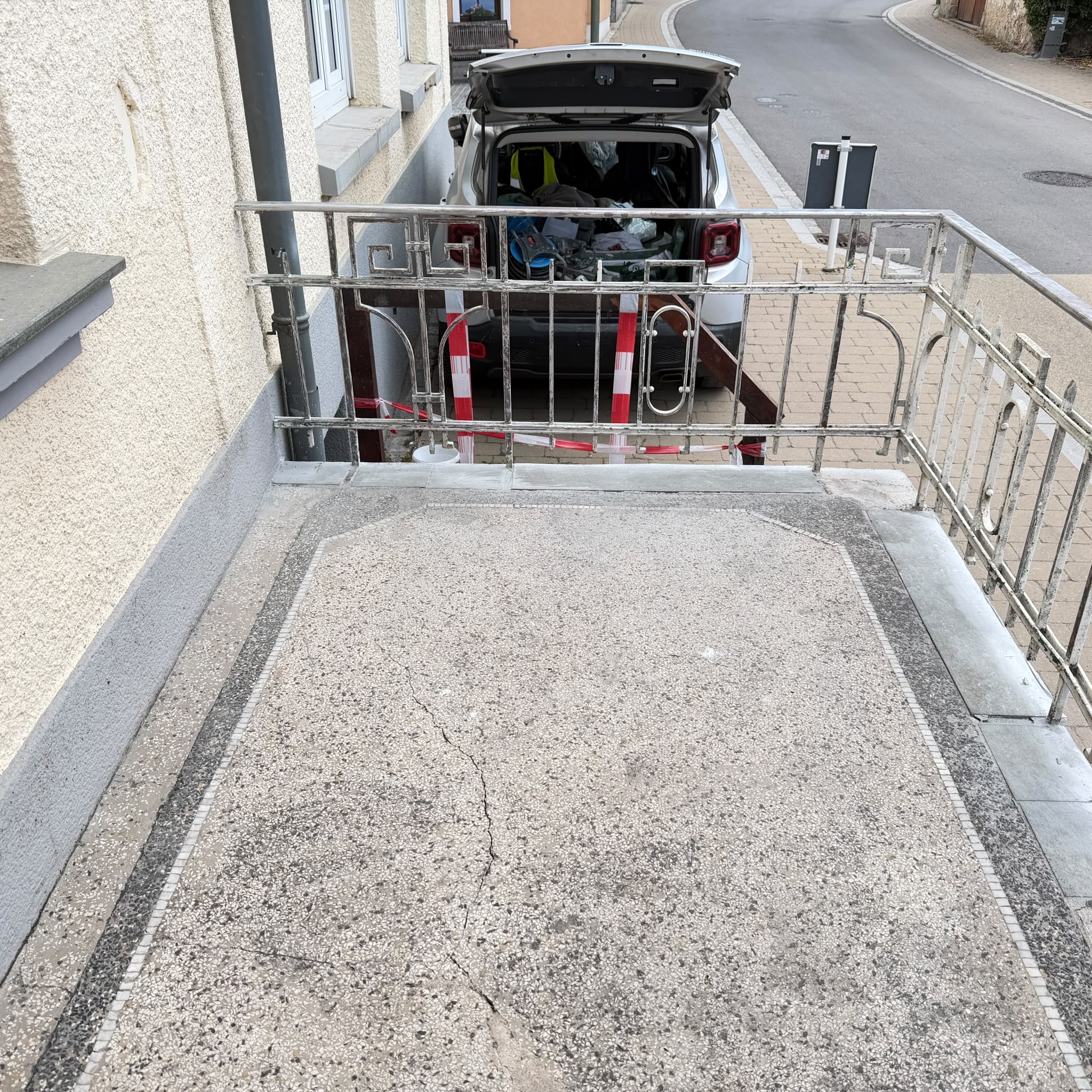 Terrasse vorher – gerissene Oberfläche mit verrostetem Geländer